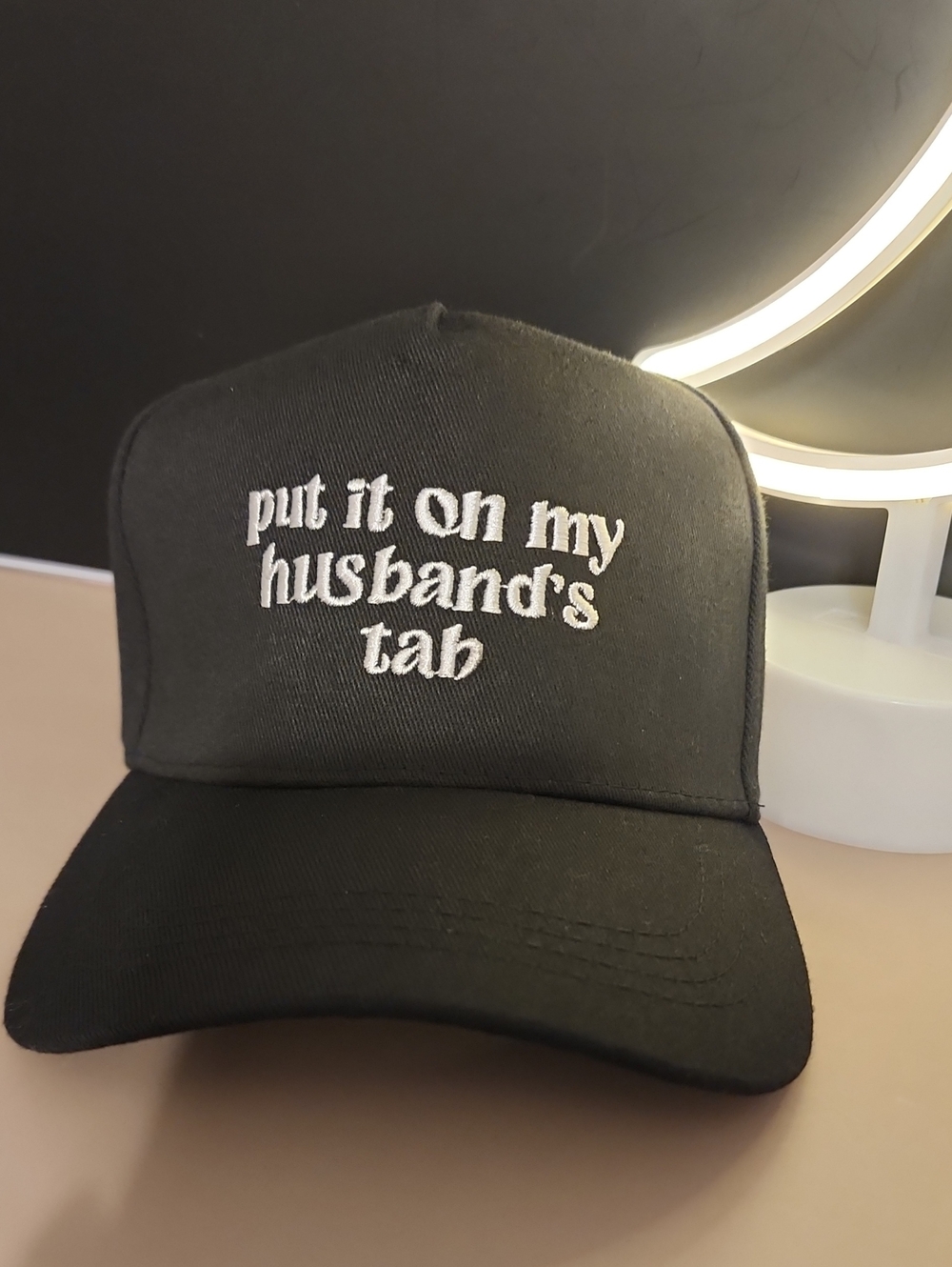 Put It On My Husband's Tab Black Embroidered Trucker Cap